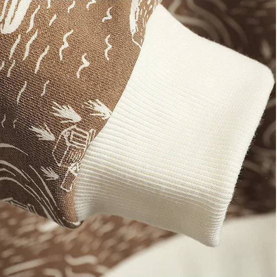 Close-up of a brown fabric with white patterns and a white sleeve.