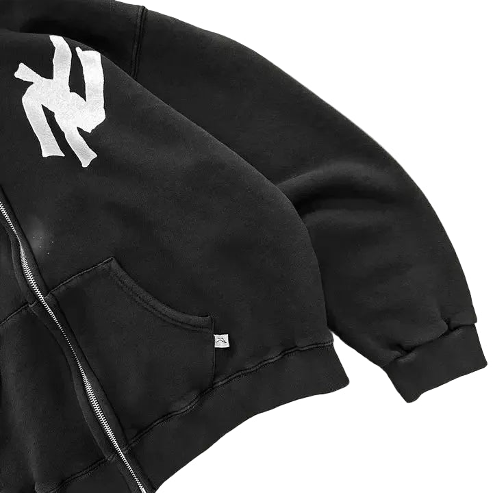 Black jacket with a logo on a gray surface