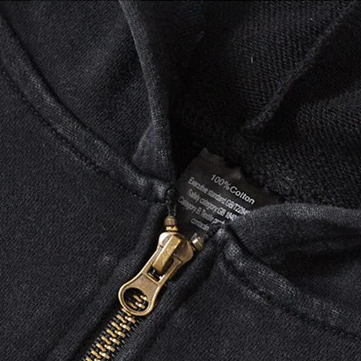 Close-up of a black jacket with a zipper, highlighting loose neckline and cuffs.