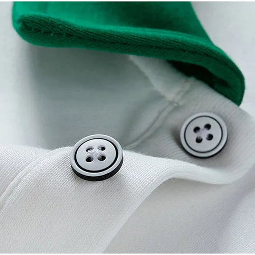 Close-up of a white shirt with green collar and buttons on a light gray background
