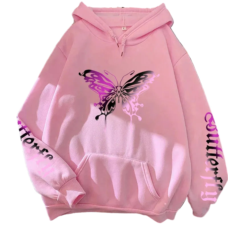 Pink hoodie with a butterfly design on a surface with books and shoes.
