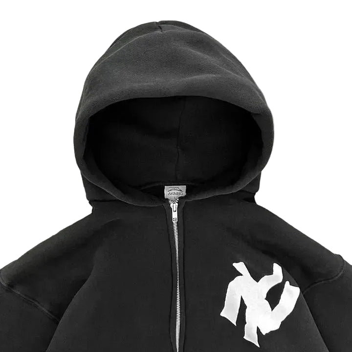 Black hoodie with a white logo on a gray concrete surface